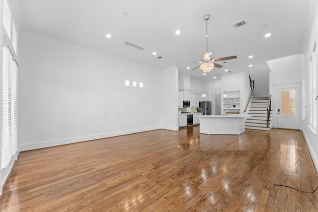 1038 E 29th St, Houston, TX 77009 - unfurnished living room featuring ceiling fan, wood finished floors, crown molding, recessed lighting, and stairway