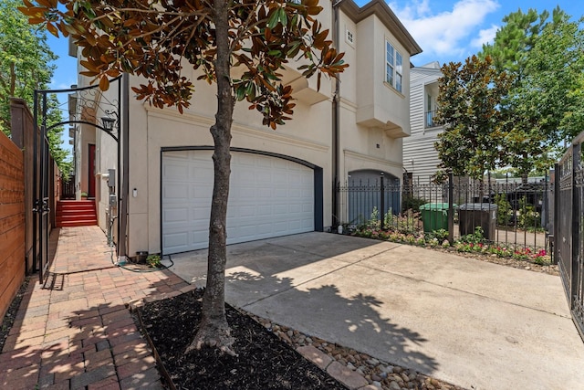 1038 E 29th St, Houston, TX 77009 - view of side of property featuring concrete driveway, a garage, and stucco siding