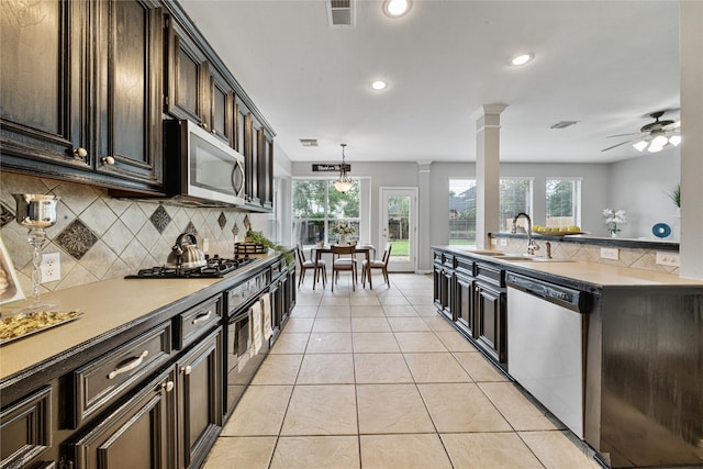 22406 Cascade Springs Dr, Katy, TX 77494 - kitchen featuring appliances with stainless steel finishes, backsplash, ornate columns, plenty of natural light, and recessed lighting