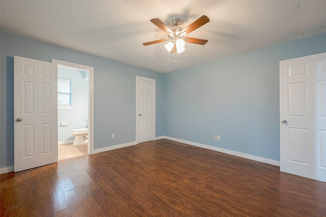 2307 N Thompson, Conroe, TX 77303 - unfurnished bedroom with dark wood-style floors, connected bathroom, a textured ceiling, and ceiling fan