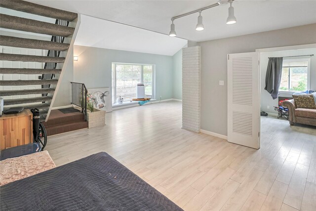 2706 Meadow Ln, La Marque, TX 77568 - interior space featuring light wood-type flooring, track lighting, lofted ceiling, and stairway