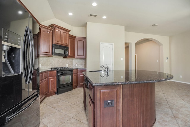 13604 Rainwater Dr, Pearland, TX 77584 - kitchen featuring black appliances, arched walkways, decorative backsplash, dark stone countertops, and recessed lighting