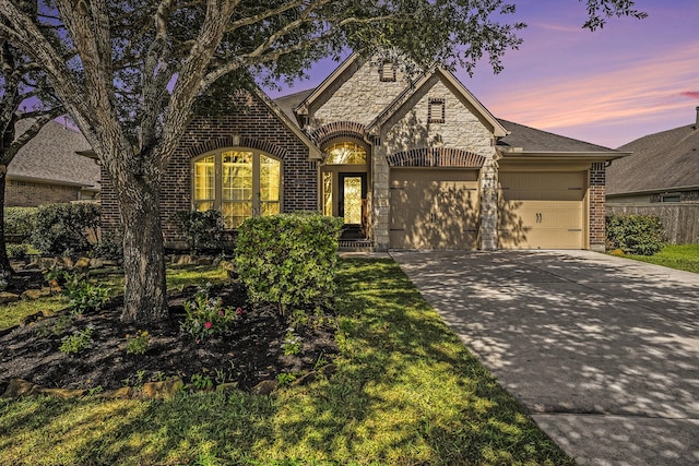 13604 Rainwater Dr, Pearland, TX 77584 - french country home with brick siding, a garage, concrete driveway, and stone siding