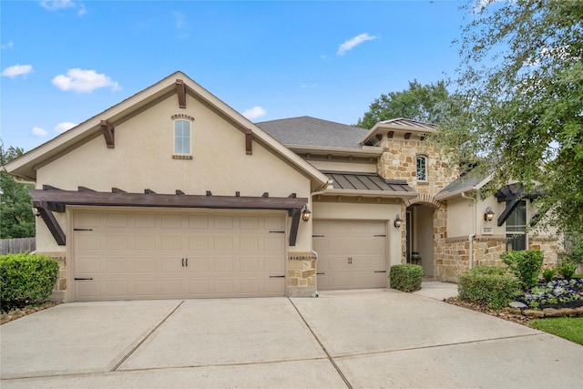 31218 Redwood Manor Ct, Spring, TX 77386 - view of front of house with stone siding, concrete driveway, a standing seam roof, and stucco siding