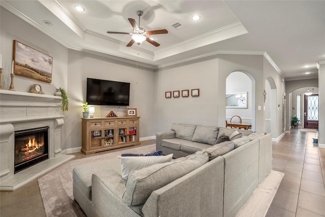 31218 Redwood Manor Ct, Spring, TX 77386 - living room featuring arched walkways, a ceiling fan, ornamental molding, a fireplace, and tile patterned flooring