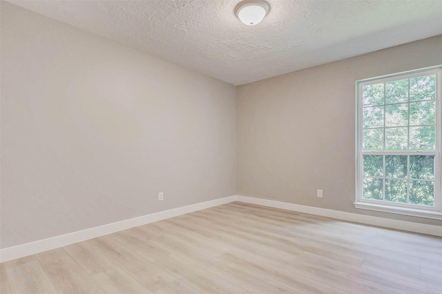 907 Kip Ln, Pinehurst, TX 77362 - spare room with light wood-style flooring and a textured ceiling