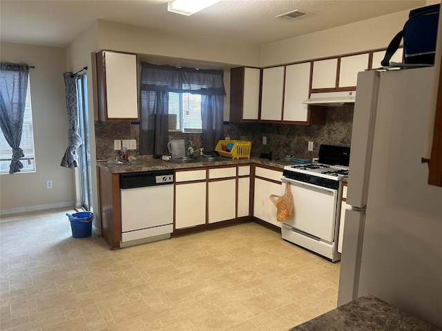 15806 Pin Oak Ridge St, Houston, TX 77073 - kitchen with white appliances, under cabinet range hood, decorative backsplash, dark countertops, and white cabinets