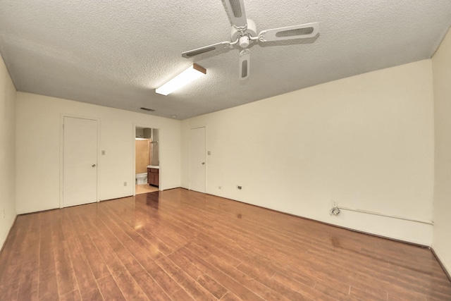 6643 Briar Glade Dr, Houston, TX 77072 - unfurnished bedroom featuring a textured ceiling, wood finished floors, ensuite bath, and ceiling fan