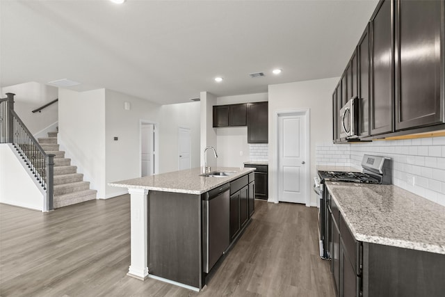 4625 Peony Green Dr, Katy, TX 77493 - kitchen featuring appliances with stainless steel finishes, wood finished floors, decorative backsplash, light stone countertops, and recessed lighting