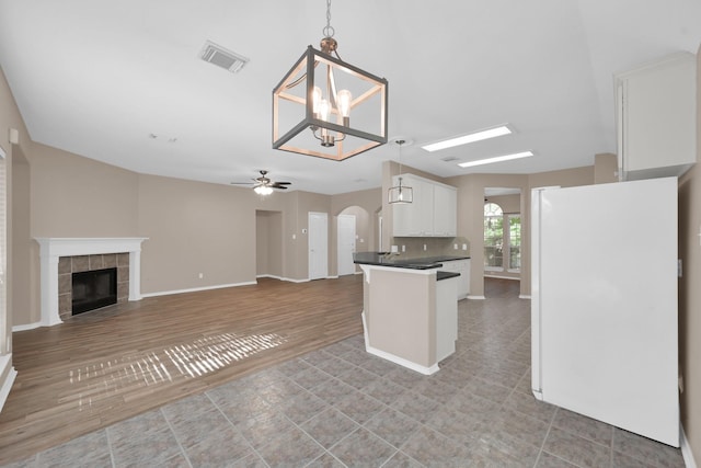 107 W Russet Grove Cir, The Woodlands, TX 77384 - kitchen with freestanding refrigerator, white cabinets, ceiling fan, dark countertops, and decorative light fixtures