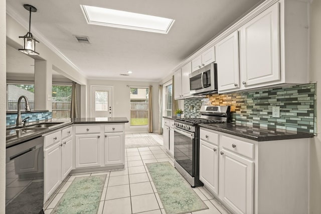5003 Blanco Dr, Pearland, TX 77584 - kitchen featuring stainless steel appliances, white cabinets, dark countertops, decorative backsplash, and crown molding