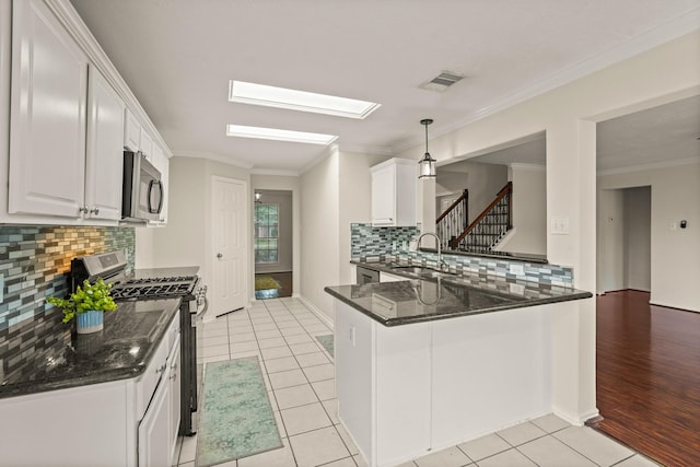 5003 Blanco Dr, Pearland, TX 77584 - kitchen featuring appliances with stainless steel finishes, white cabinetry, crown molding, light tile patterned floors, and decorative backsplash