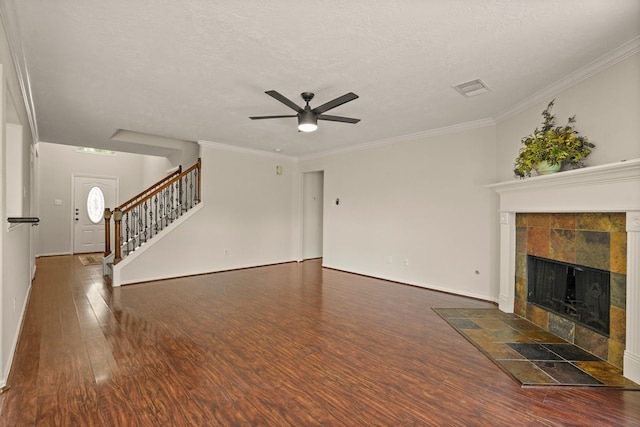 5003 Blanco Dr, Pearland, TX 77584 - unfurnished living room featuring a ceiling fan, wood finished floors, stairway, a tiled fireplace, and a textured ceiling