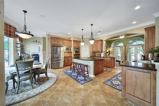 23815 Enchanted Xing, Katy, TX 77494 - kitchen with appliances with stainless steel finishes, plenty of natural light, dark countertops, arched walkways, and ornamental molding