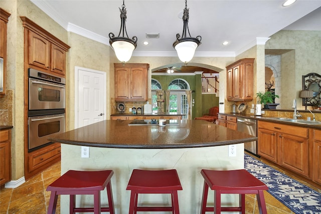23815 Enchanted Xing, Katy, TX 77494 - kitchen featuring appliances with stainless steel finishes, a center island, arched walkways, a kitchen bar, and ornamental molding