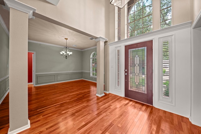 1808 Brookside Dr, Friendswood, TX 77546 - foyer featuring ornate columns, ornamental molding, wood finished floors, a chandelier, and a decorative wall