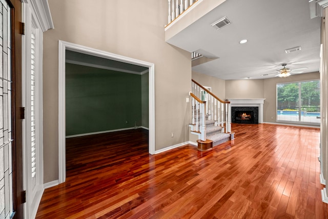 1808 Brookside Dr, Friendswood, TX 77546 - unfurnished living room featuring wood finished floors, a ceiling fan, stairs, and a premium fireplace