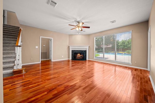 1808 Brookside Dr, Friendswood, TX 77546 - unfurnished living room with a ceiling fan, stairs, wood finished floors, and a high end fireplace