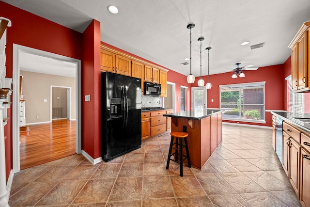 1808 Brookside Dr, Friendswood, TX 77546 - kitchen featuring black appliances, a kitchen island, ceiling fan, dark countertops, and backsplash