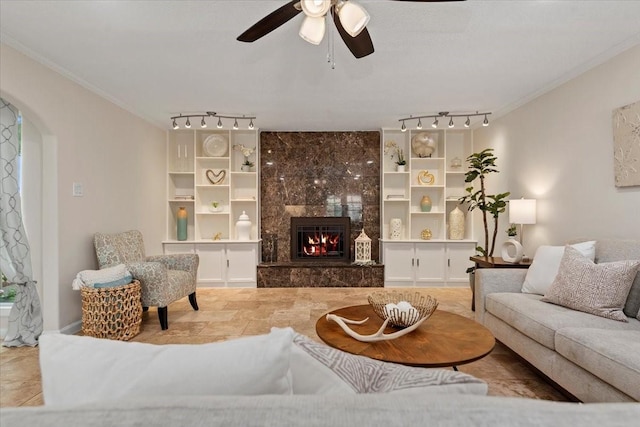 15502 Rana Ct, Houston, TX 77068 - living area with track lighting, ornamental molding, ceiling fan, a fireplace, and built in shelves
