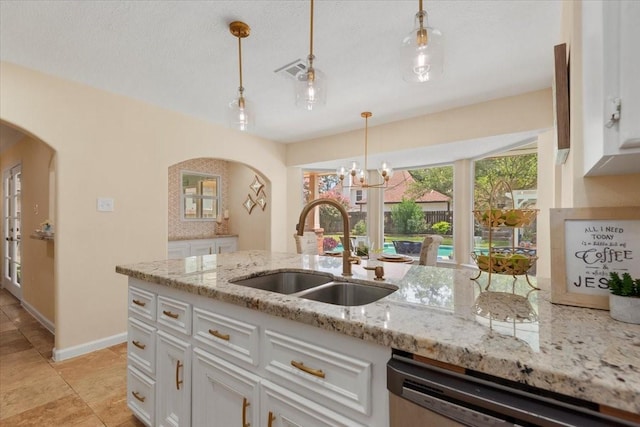 15502 Rana Ct, Houston, TX 77068 - kitchen with arched walkways, stainless steel dishwasher, white cabinets, hanging light fixtures, and light stone countertops