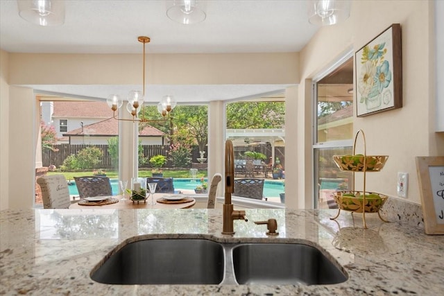 15502 Rana Ct, Houston, TX 77068 - kitchen with a chandelier, stone countertops, and hanging light fixtures