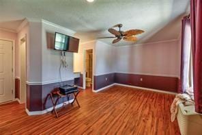 2884 W Fm 1988, Livingston, TX 77351 - unfurnished living room with a ceiling fan, crown molding, wood finished floors, and vaulted ceiling