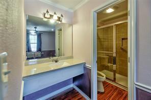 2884 W Fm 1988, Livingston, TX 77351 - full bathroom featuring crown molding, vanity, a shower stall, and wood finished floors