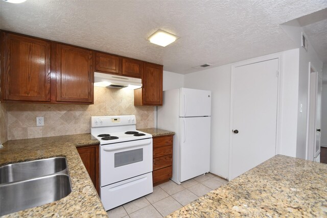 10018 Knoboak Dr Unit 21, Houston, TX 77080 - kitchen featuring white appliances, under cabinet range hood, backsplash, light tile patterned floors, and a textured ceiling