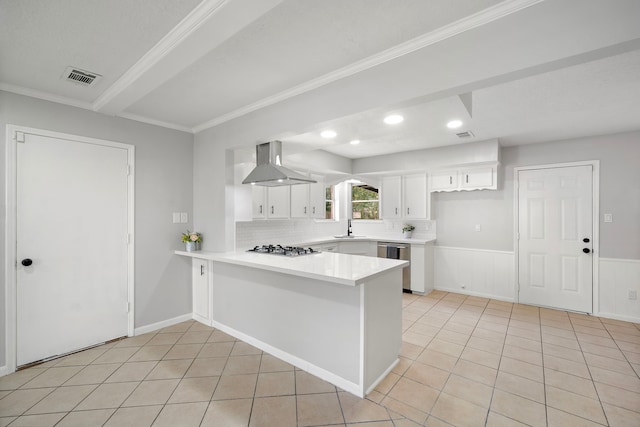 21710 Rotherham Dr, Spring, TX 77388 - kitchen featuring wall chimney exhaust hood, stainless steel appliances, a peninsula, white cabinetry, and light tile patterned floors