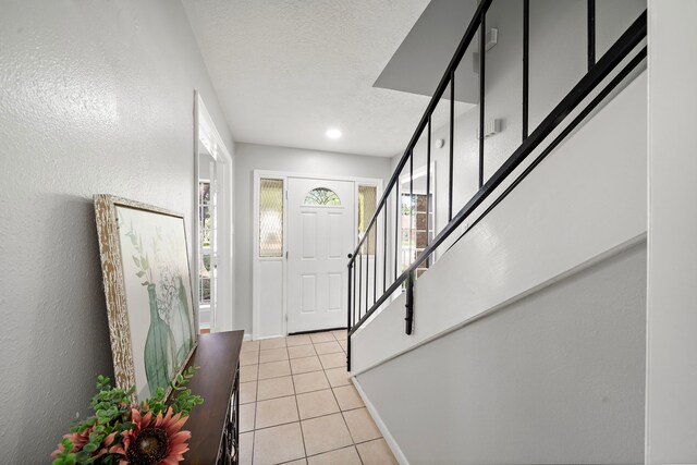 21710 Rotherham Dr, Spring, TX 77388 - entrance foyer featuring stairway, light tile patterned floors, and a textured ceiling