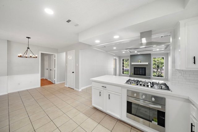 21710 Rotherham Dr, Spring, TX 77388 - kitchen featuring stainless steel appliances, wall chimney range hood, light countertops, recessed lighting, and white cabinetry