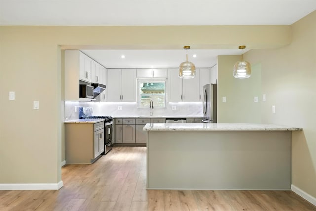 11726 Gardenglen Dr, Houston, TX 77070 - kitchen with appliances with stainless steel finishes, a peninsula, tasteful backsplash, light wood-style flooring, and recessed lighting