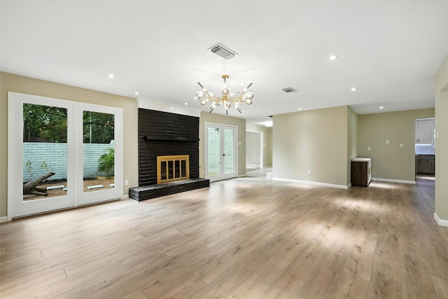 11726 Gardenglen Dr, Houston, TX 77070 - unfurnished living room featuring a chandelier, light wood-style floors, a brick fireplace, and recessed lighting