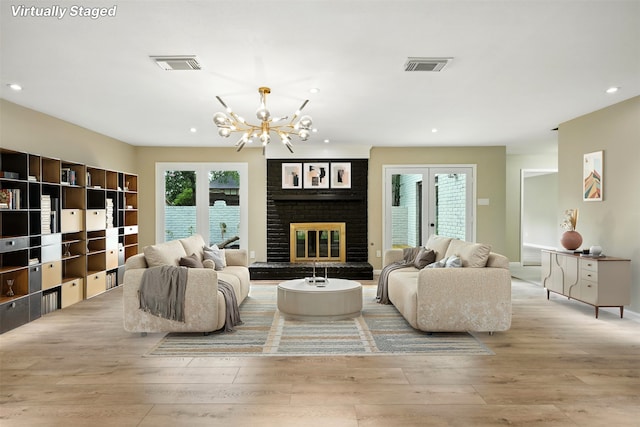 11726 Gardenglen Dr, Houston, TX 77070 - living room featuring hardwood / wood-style flooring, a chandelier, recessed lighting, and a brick fireplace