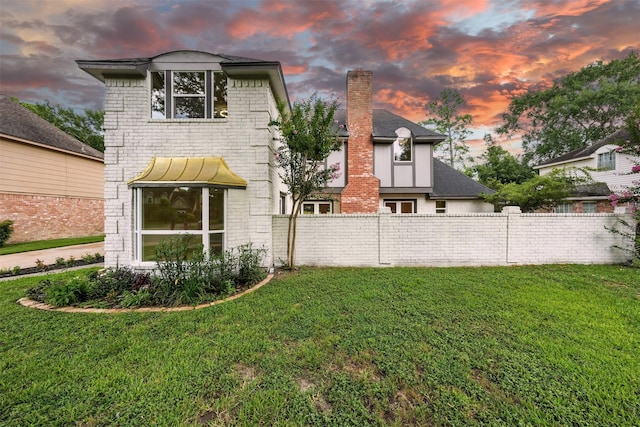 11726 Gardenglen Dr, Houston, TX 77070 - back of house at dusk with a chimney and brick siding