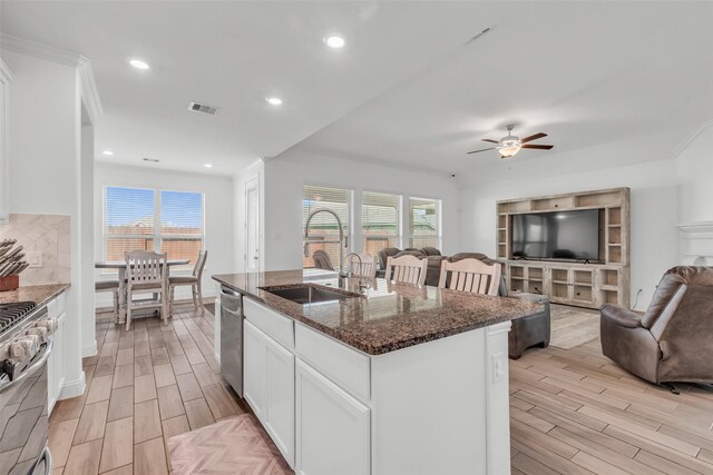 505 Ozark Ct, League City, TX 77573 - kitchen featuring open floor plan, light wood finished floors, appliances with stainless steel finishes, dark stone counters, and ceiling fan