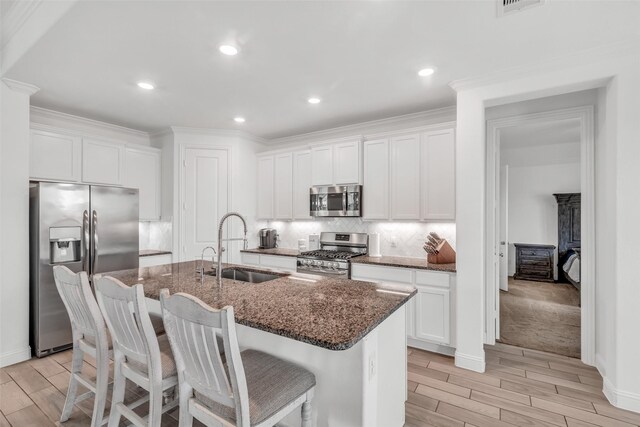 505 Ozark Ct, League City, TX 77573 - kitchen with appliances with stainless steel finishes, wood finish floors, backsplash, dark stone counters, and ornamental molding