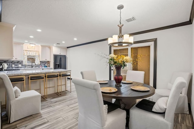 208 Moss Hill Ln, Conroe, TX 77303 - dining area featuring ornamental molding, a chandelier, recessed lighting, and light wood-style floors
