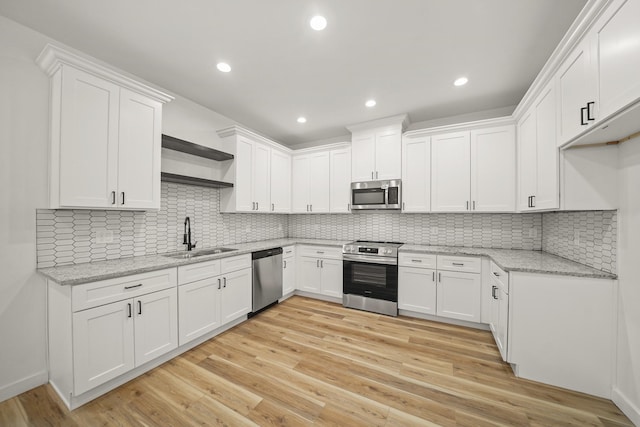 6206 Lyndhurst Dr, Houston, TX 77087 - kitchen featuring appliances with stainless steel finishes, open shelves, white cabinets, light stone countertops, and recessed lighting