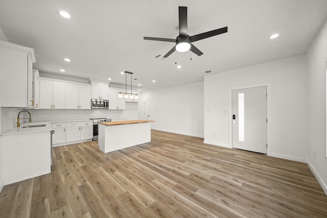 6206 Lyndhurst Dr, Houston, TX 77087 - kitchen featuring stainless steel appliances, a center island, recessed lighting, a ceiling fan, and decorative backsplash