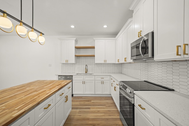 6206 Lyndhurst Dr, Houston, TX 77087 - kitchen with appliances with stainless steel finishes, butcher block counters, open shelves, white cabinets, and light wood-style flooring