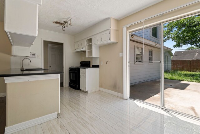 8631 Alcott Dr, Houston, TX 77080 - kitchen with black gas range oven, dark countertops, white cabinetry, a textured ceiling, and under cabinet range hood
