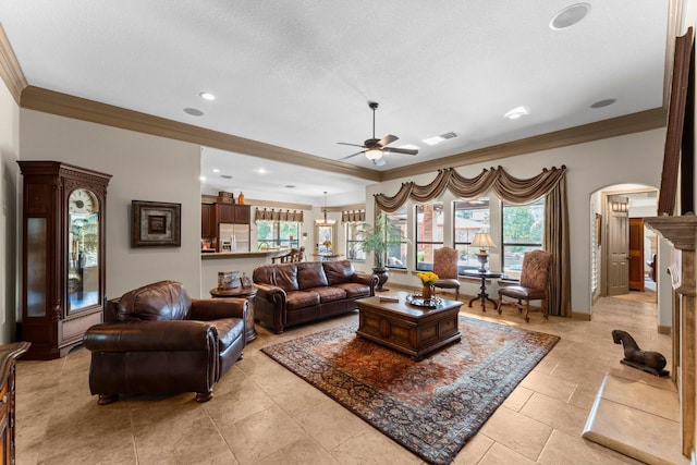 12218 Johns Enterprise Ct, Cypress, TX 77433 - living room with ornamental molding, arched walkways, ceiling fan, healthy amount of natural light, and a textured ceiling