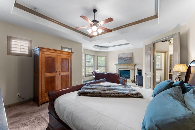 12218 Johns Enterprise Ct, Cypress, TX 77433 - bedroom featuring a raised ceiling, light carpet, a glass covered fireplace, crown molding, and a ceiling fan