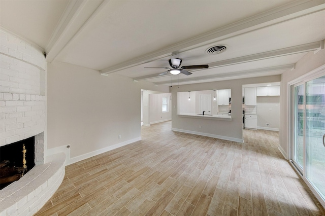 8822 Rowan Ln, Houston, TX 77036 - unfurnished living room featuring beam ceiling, light wood finished floors, ceiling fan, and a fireplace