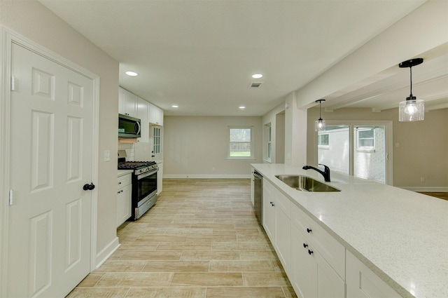 8822 Rowan Ln, Houston, TX 77036 - kitchen with appliances with stainless steel finishes, white cabinetry, recessed lighting, pendant lighting, and light stone counters
