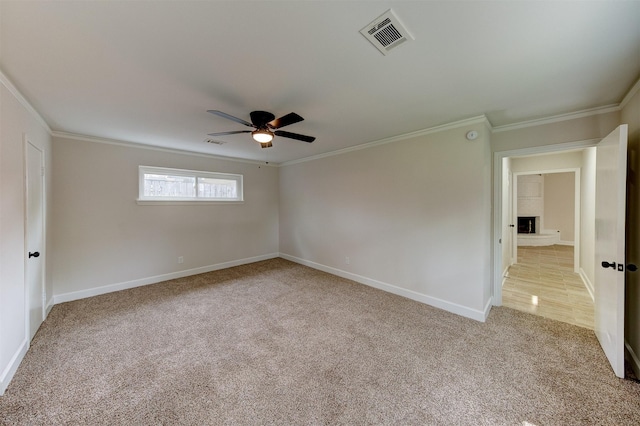 8822 Rowan Ln, Houston, TX 77036 - spare room with ornamental molding, ceiling fan, light carpet, and a large fireplace