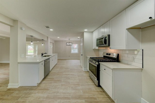 8822 Rowan Ln, Houston, TX 77036 - kitchen with stainless steel appliances, decorative backsplash, white cabinets, and recessed lighting