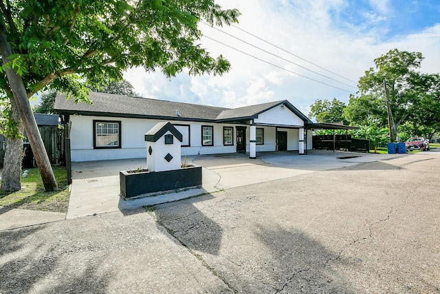 910 11th St, South Houston, TX 77587 - view of front of home with stucco siding, a shingled roof, driveway, and an attached carport